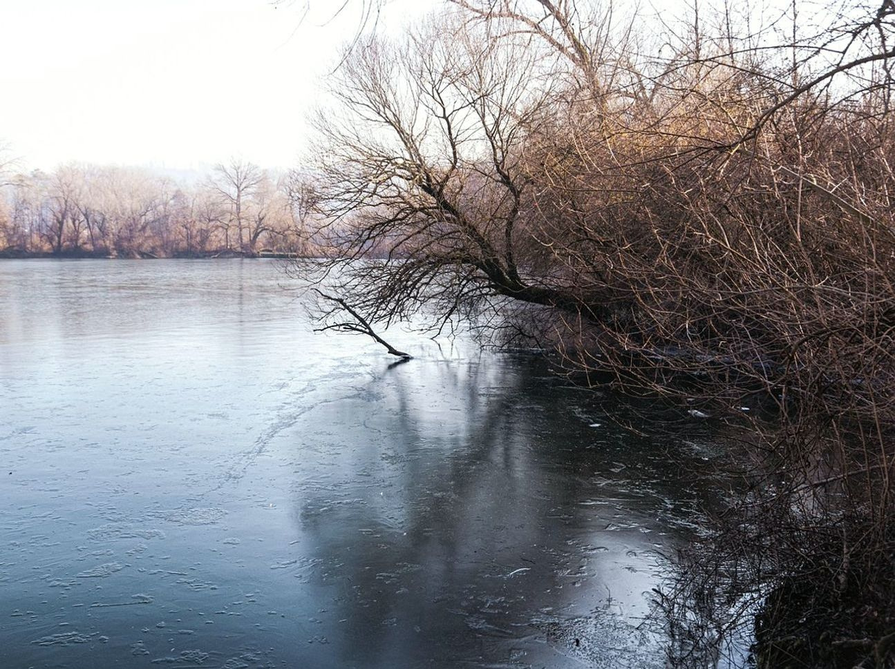 Un lago bajo el hielo al amanecer, antes de que baje el sol